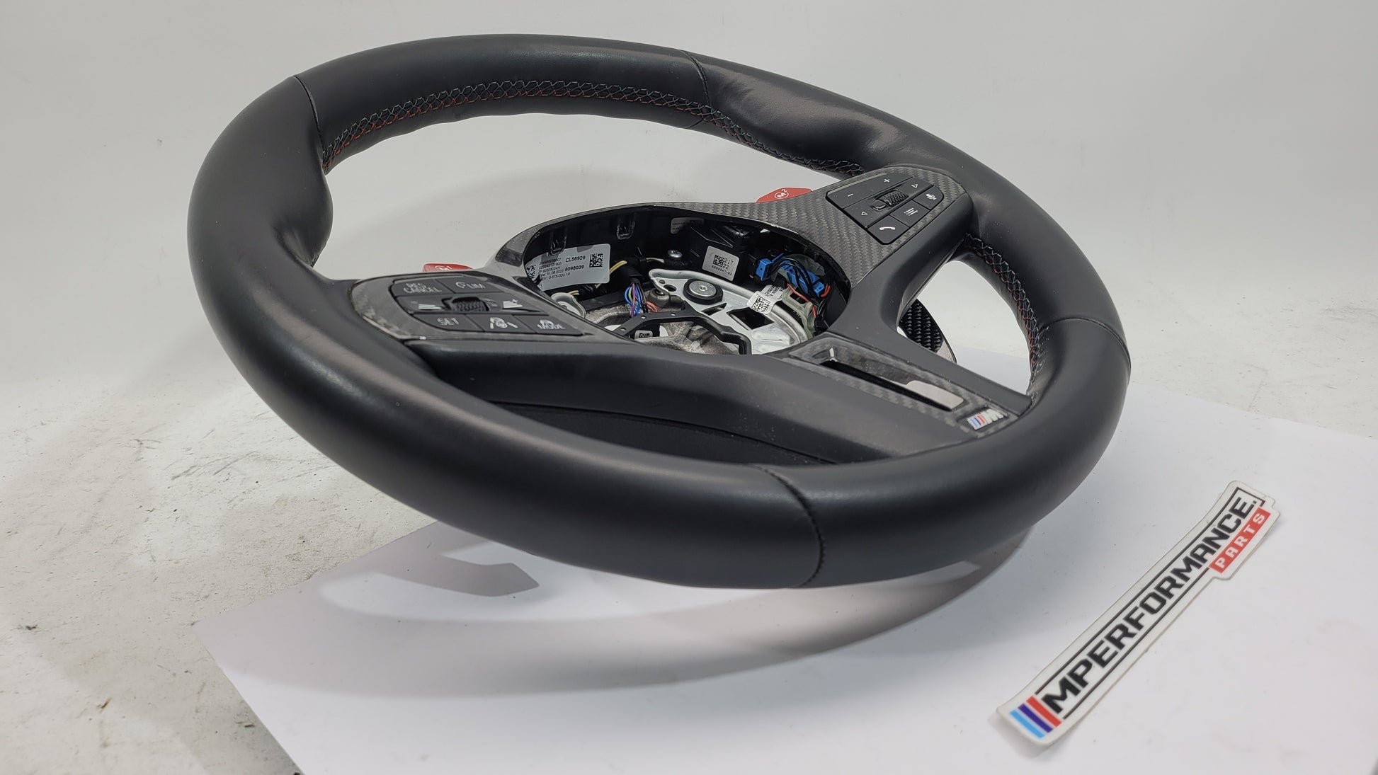 BMW M2 M3 M4 G80 G82 leather M steering wheel with black finish and MPerformance.parts branding, close-up view of the steering wheel.
