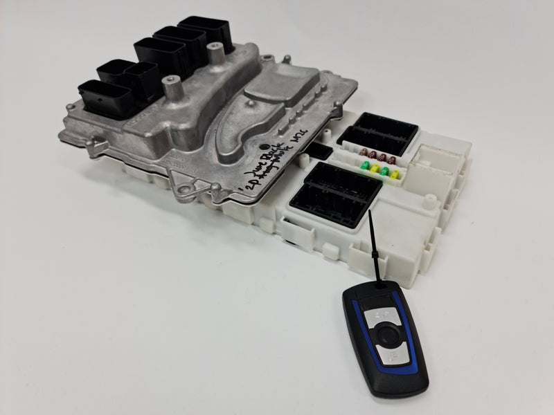 BMW F80 F82 F87 M2 M3 M4 S55 engine ECU DME FEM control unit with key, showing circuit boards and connection ports.