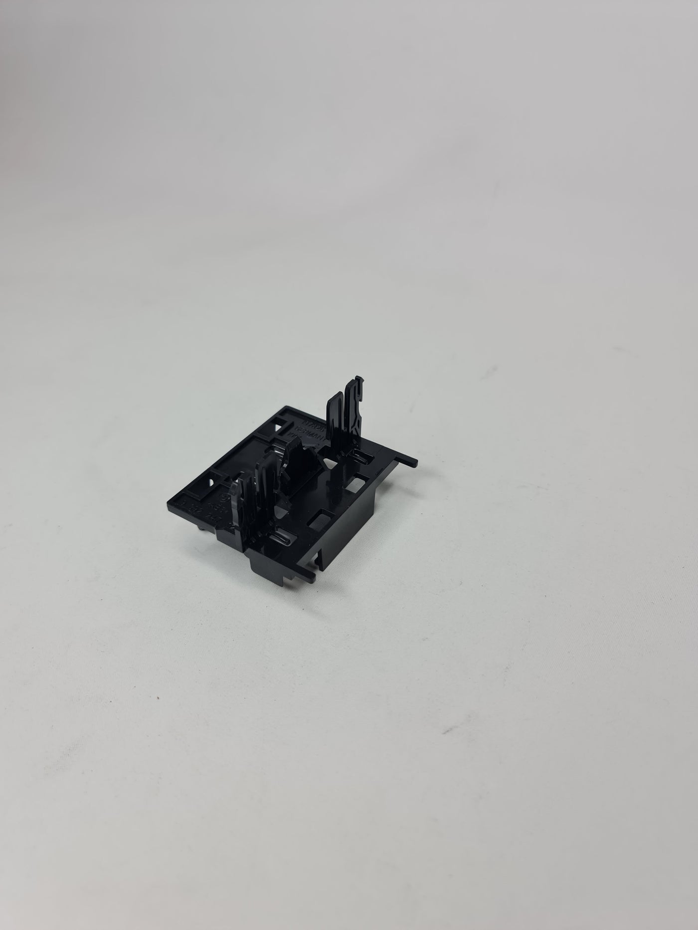 BMW control unit module holder for 2014-2020 models, black plastic component with mounting points and branding details.